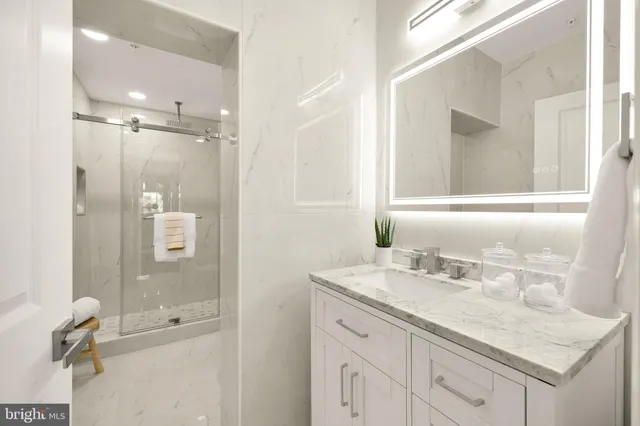 a bathroom with a shower sink vanity and mirror