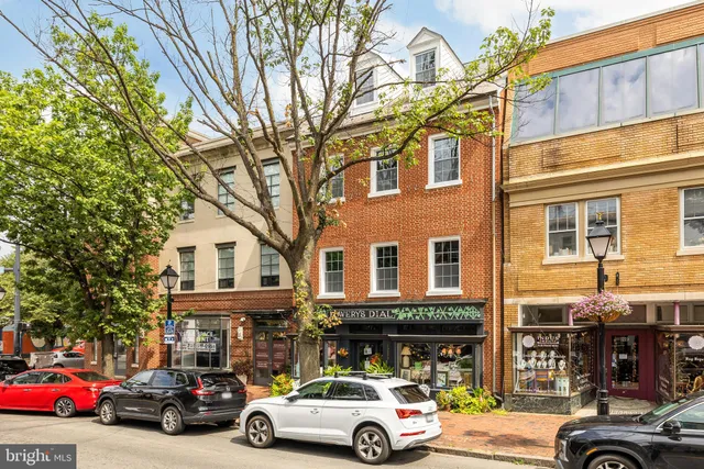 a front view of a building with cars parked