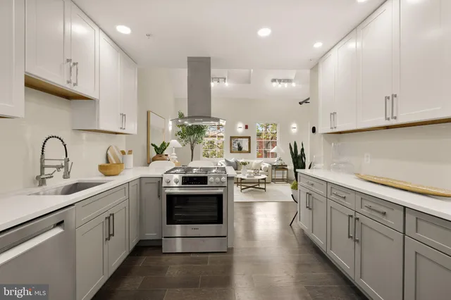 a kitchen with stainless steel appliances granite countertop a sink stove and cabinets
