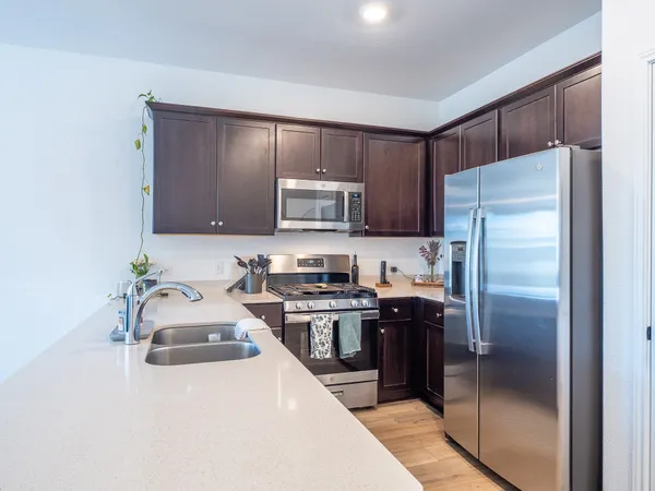a kitchen with granite countertop a refrigerator and a stove top oven