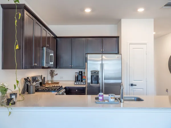 a kitchen with kitchen island granite countertop a refrigerator and a sink