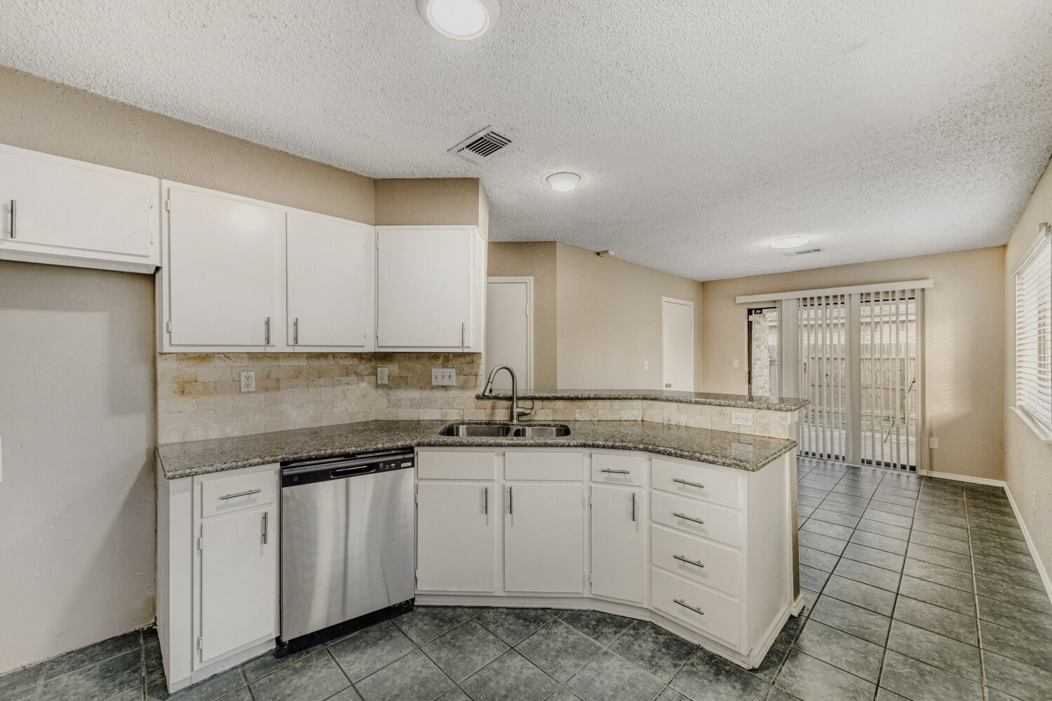 9727 Orangevale Drive Spring, TX 77379 - Photo 6 of 26 a kitchen with granite countertop white cabinets and white appliances