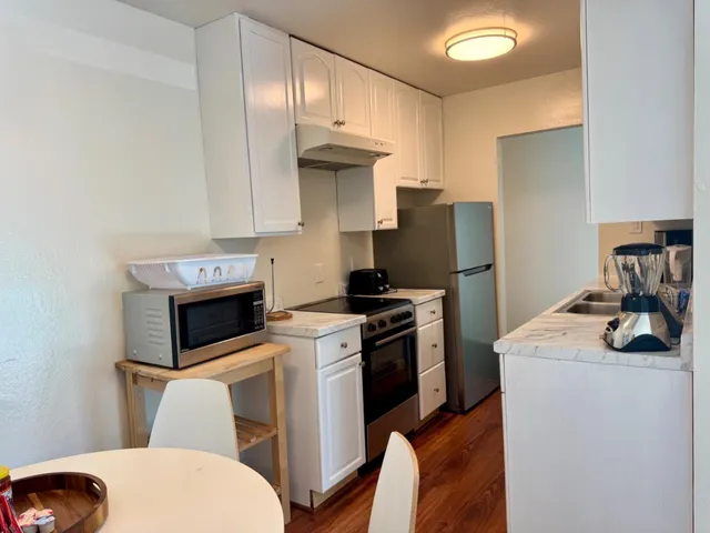 a kitchen with stainless steel appliances a white stove top oven and a white cabinets