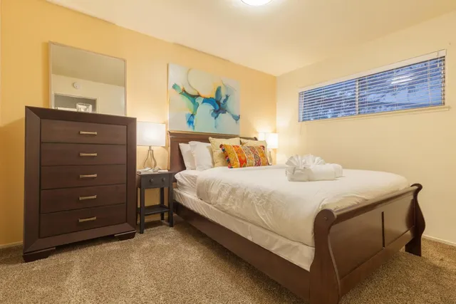 a bedroom with a bed and a painting on the wall