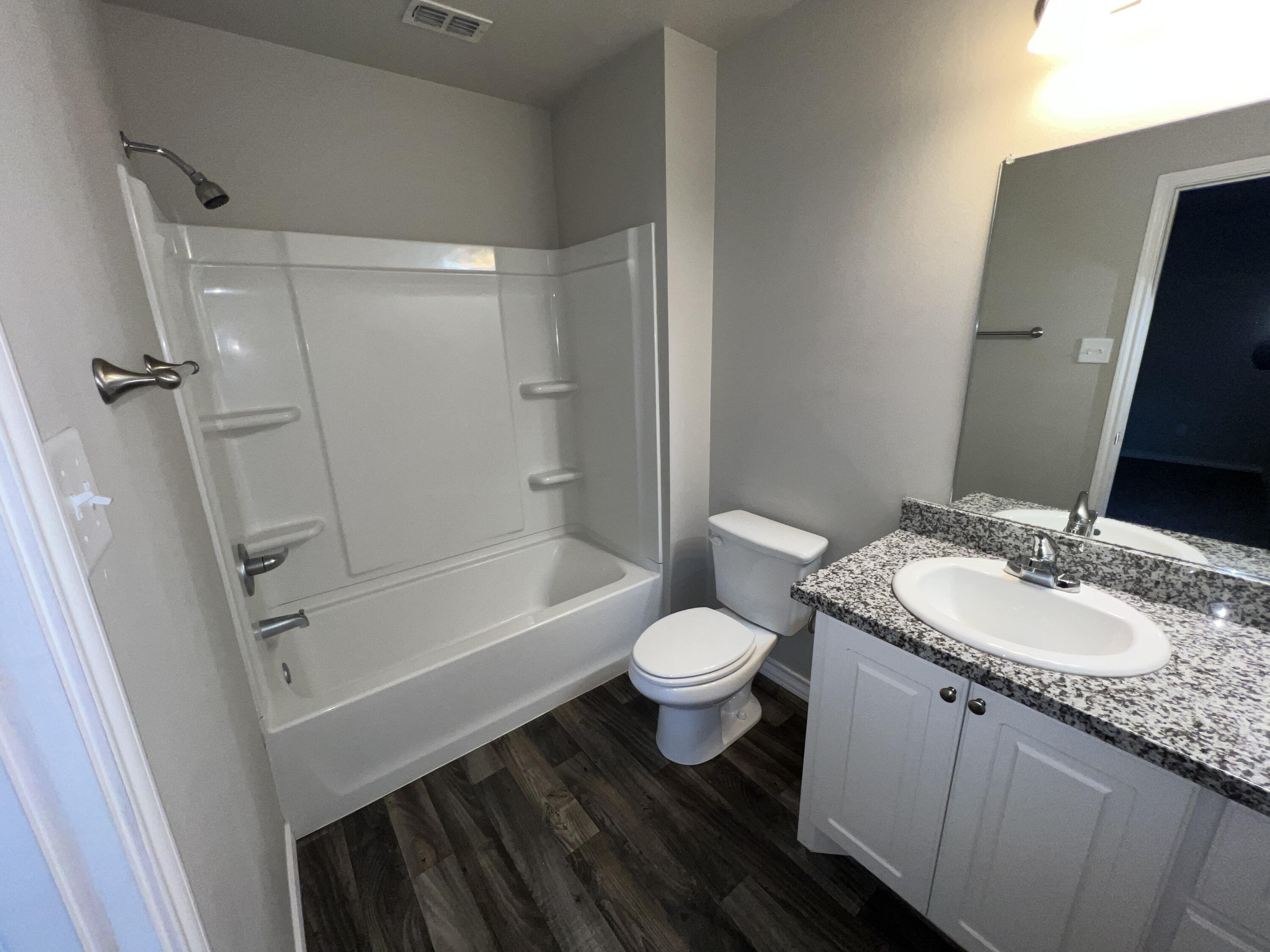 6040 24th Street, Unit 43 Lubbock, TX 79407 - Photo 11 of 11 a bathroom with a sink a toilet a mirror and shower