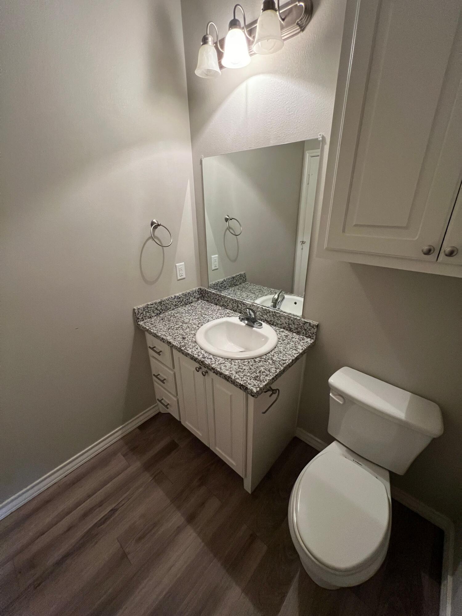 6040 24th Street, Unit 43 Lubbock, TX 79407 - Photo 4 of 11 a bathroom with a granite countertop toilet sink and mirror