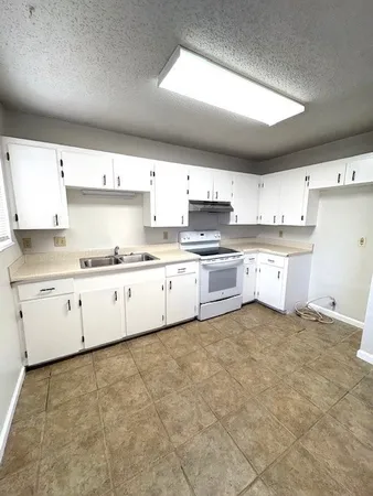a large kitchen with cabinets and stainless steel appliances