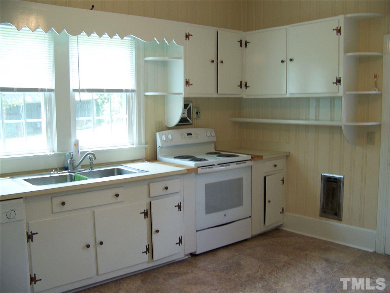 2114 Sanders Road Stem, NC 27581 - Photo 12 of 23 a kitchen with granite countertop white cabinets and window