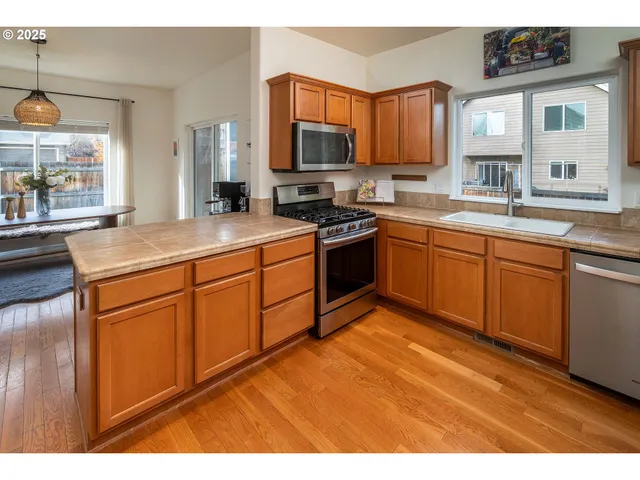 a kitchen with stainless steel appliances granite countertop a sink stove and microwave