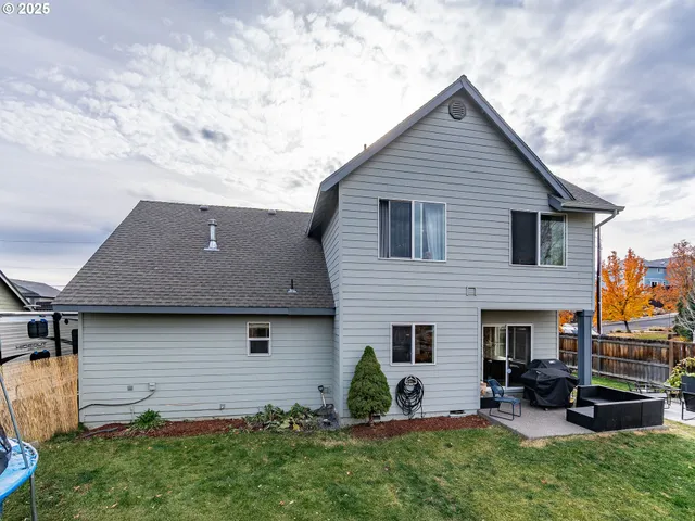 a view of a chair and table in backyard of the house