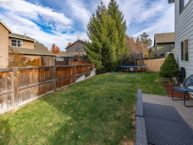 a view of a chairs and table in the back yard of a house