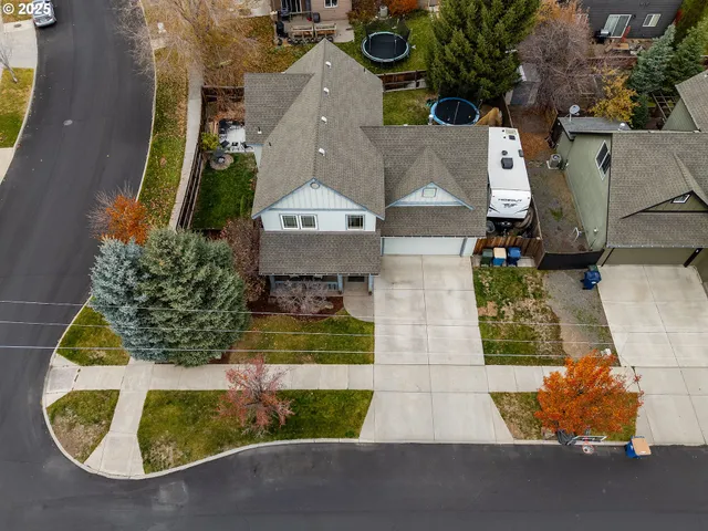 an aerial view of a house with a yard and wooden deck
