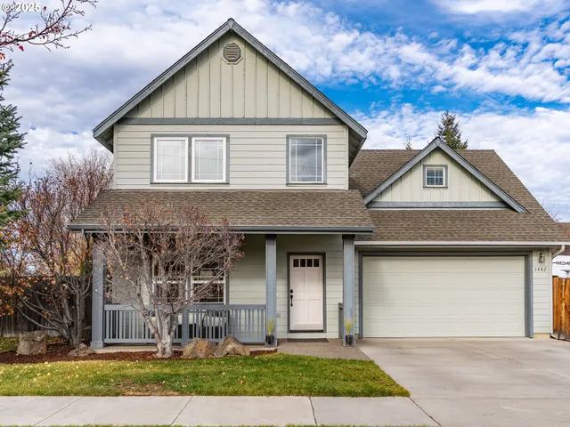 a front view of a house with a garden and plants