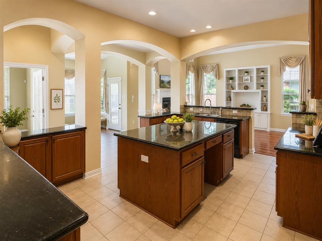 5708 Rickshaw Lane Plano, TX 75094 - Photo 10 of 28 Spacious kitchen featuring dark countertops, light-toned tiled flooring, and multiple archways