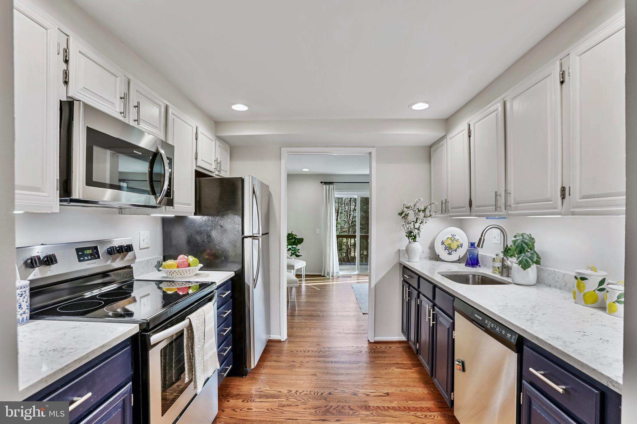 2257 Wheelwright Court Reston, VA 20191 - Photo 9 of 40 a kitchen with kitchen island granite countertop a sink wooden cabinets and stainless steel appliances