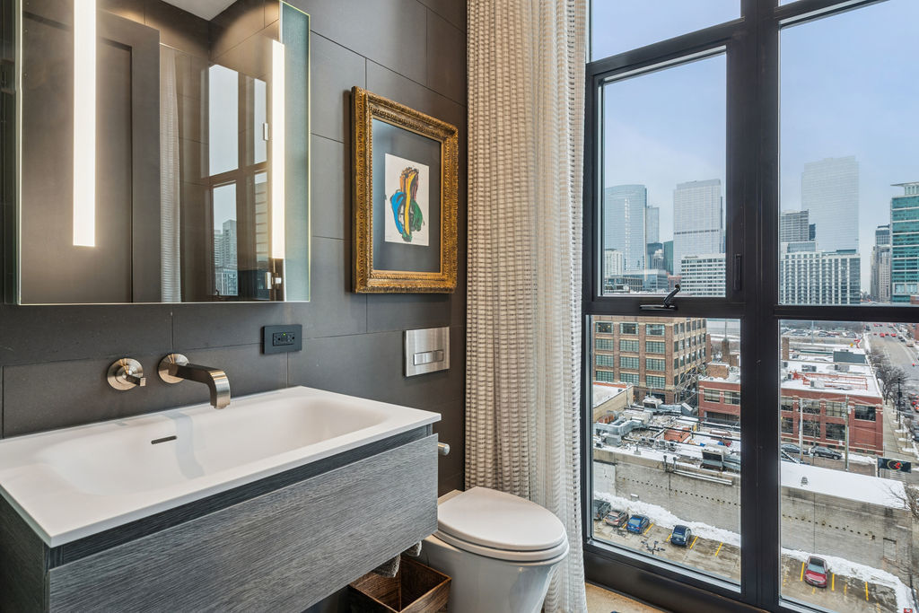 900 West Washington Boulevard, Unit 802 Chicago, IL 60607 - Photo 19 of 36 a bathroom with a sink mirror toilet and next to a window