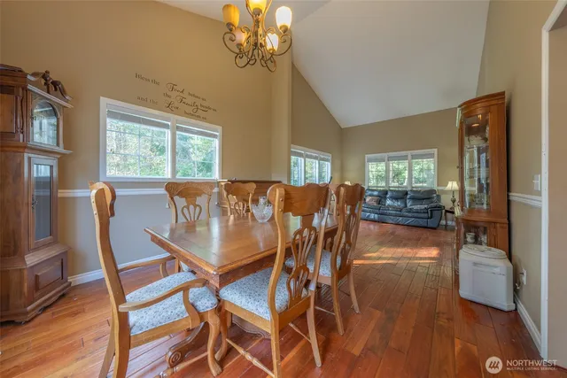 a dining room with furniture a chandelier and wooden floor