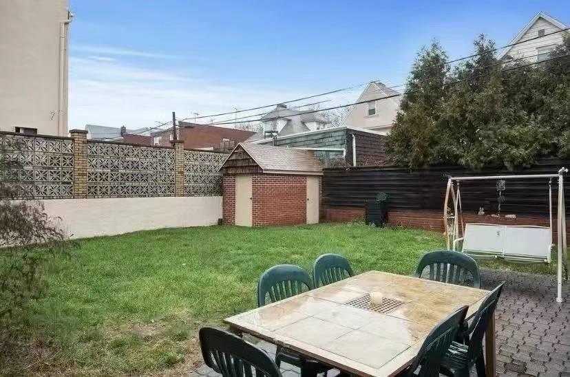 1433 Bay Ridge Parkway Brooklyn, NY 11228 - Photo 7 of 8 a view of a patio with table and chairs with wooden fence and plants