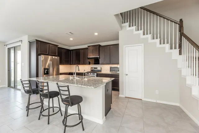 a kitchen with refrigerator and cabinets
