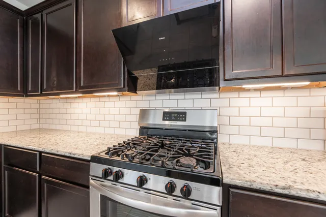 a kitchen with granite countertop a stove and a microwave