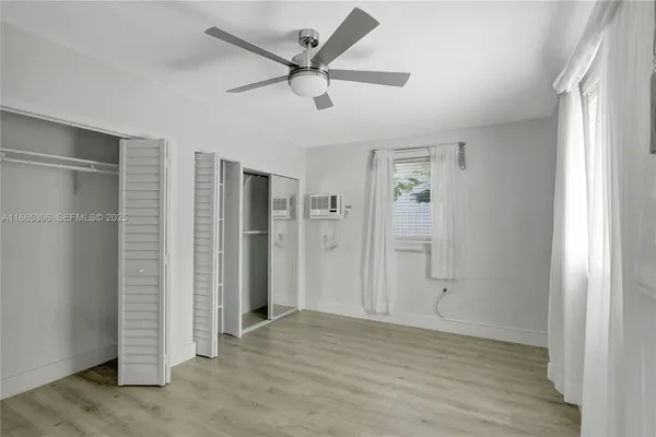 a view of a livingroom with a ceiling fan & entryway