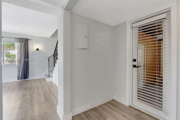 a view of a hallway with wooden floor and a cabinet