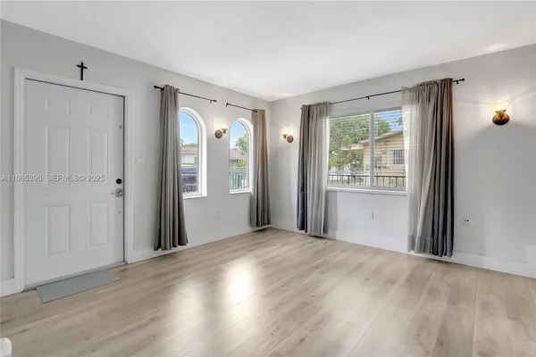 a view of a room with wooden floor and windows