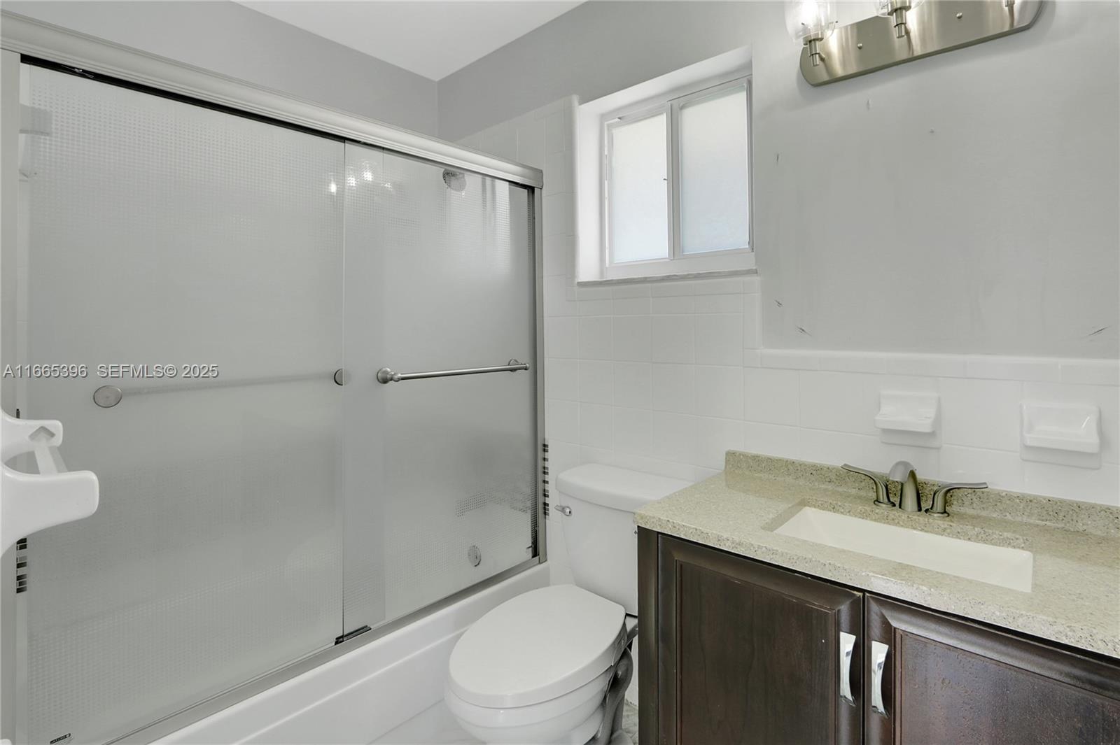 1359 Southwest 11th Street Miami, FL 33135 - Photo 10 of 25 a bathroom with a granite countertop sink toilet and shower