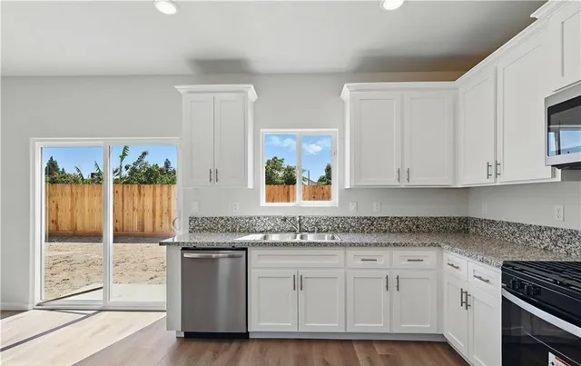 a kitchen with granite countertop white cabinets and white appliances