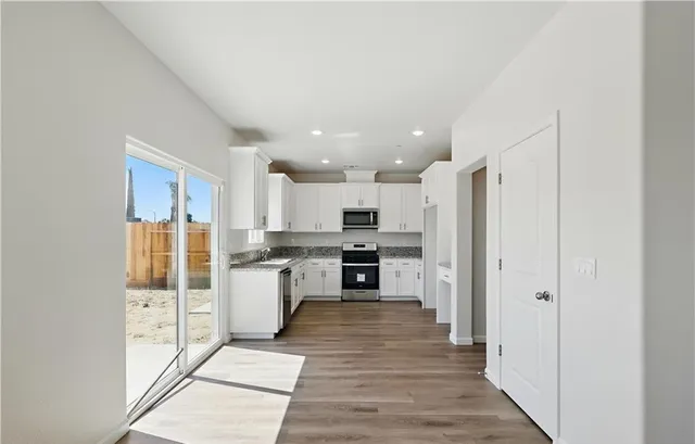 a kitchen with stainless steel appliances a refrigerator and a stove top oven
