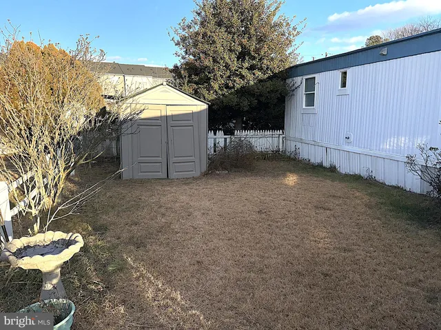 a view of a chair and table in backyard of the house