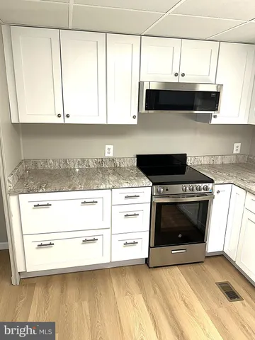 a kitchen with stainless steel appliances a stove a sink and a microwave