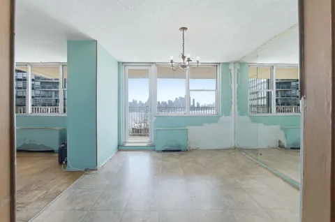 a room with a large window and chandelier