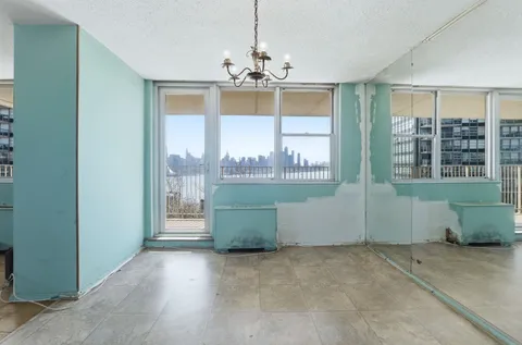 a view of a kitchen with refrigerator and an empty room