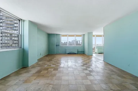 a view of a big room with closet and windows