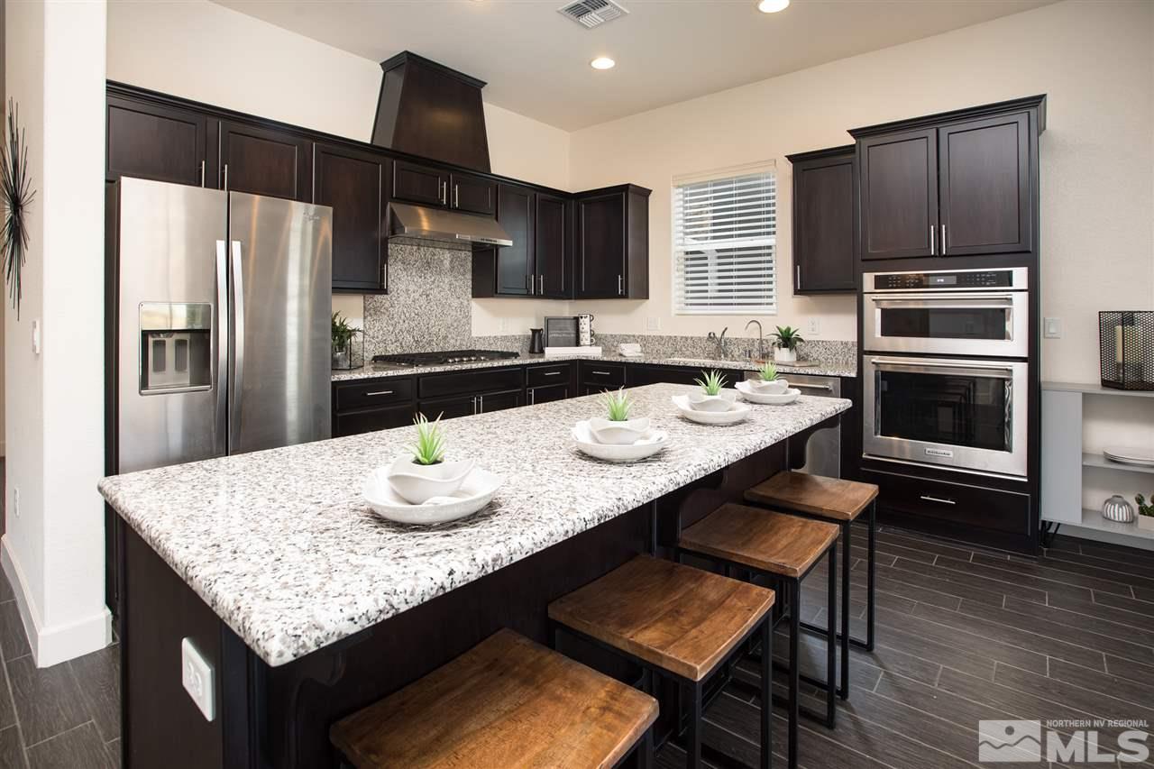 3115 Show Jumper Lane Reno, NV 89521 - Photo 13 of 25 a kitchen with granite countertop kitchen island stainless steel appliances a sink stove and refrigerator