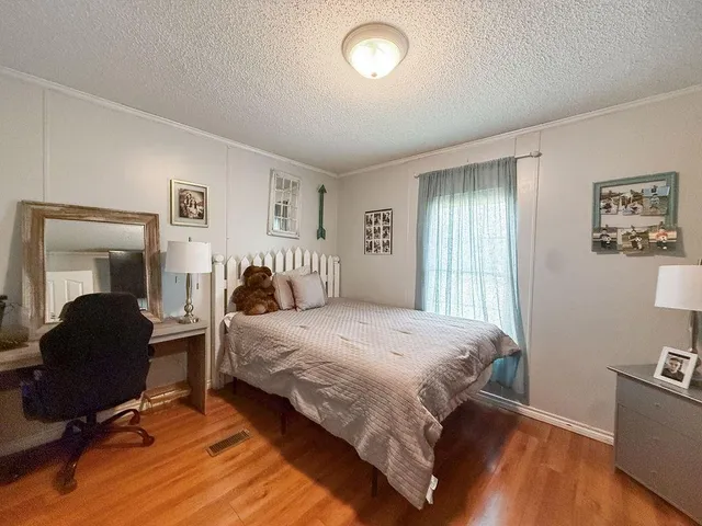 a bedroom with a bed and wooden floor
