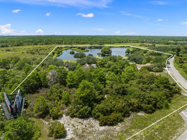 a aerial view of a house with a yard and lake view