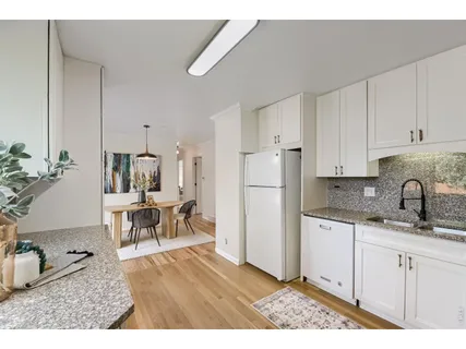 a kitchen with white cabinets and appliances