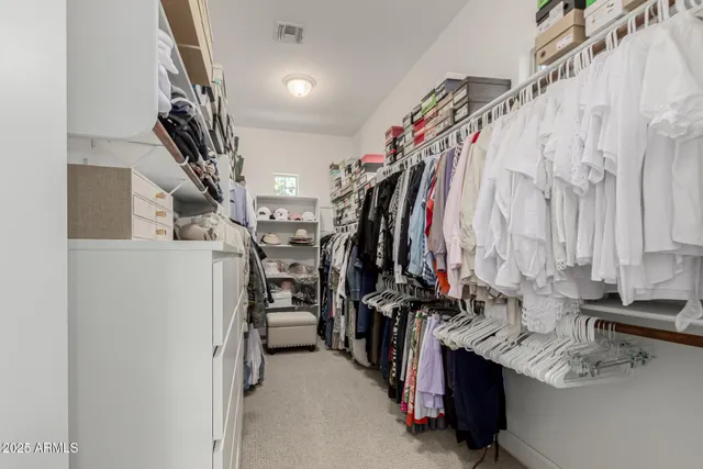 a view of walk in closet with clothes and shoes