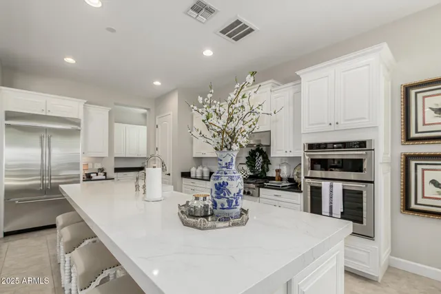 a kitchen with stainless steel appliances a stove a sink a microwave a refrigerator and cabinets