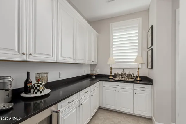 a kitchen with white cabinets and sink