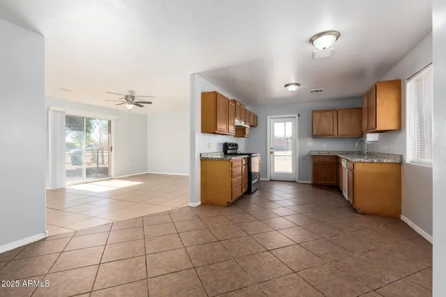 a kitchen with granite countertop a stove a sink and a refrigerator