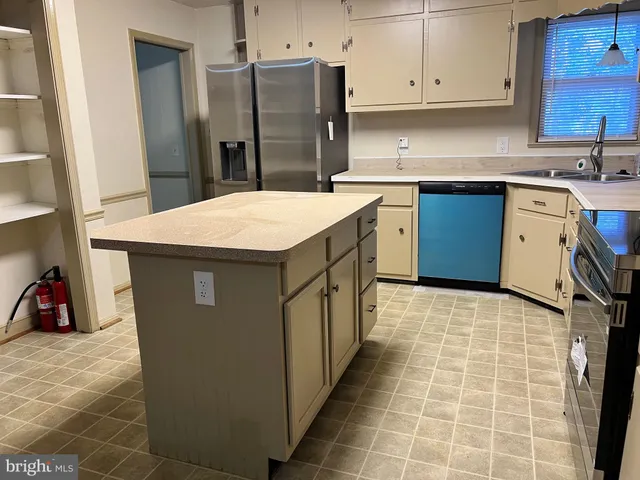 a kitchen with stainless steel appliances granite countertop a stove a refrigerator and a cabinets