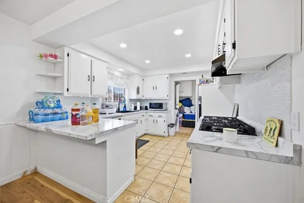 a kitchen filled with kitchen island a sink a stove and a refrigerator