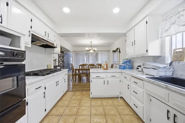 a kitchen with granite countertop a sink stove and cabinets