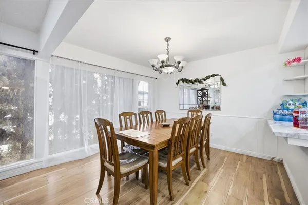 a dining room with furniture a chandelier and wooden floor