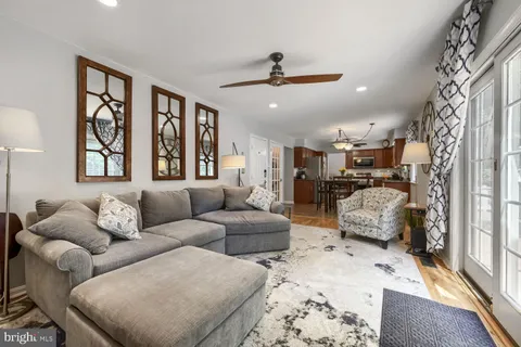 a living room with furniture ceiling fan and a window