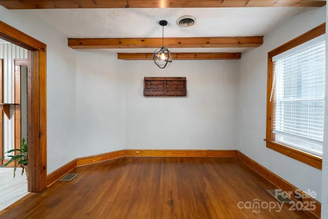 a view of a room with wooden floor and large window