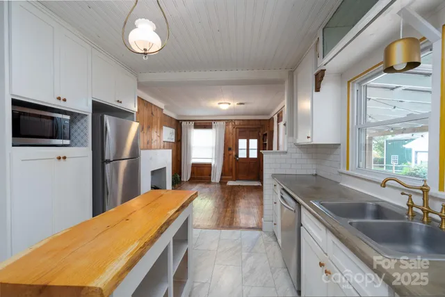 a kitchen with stainless steel appliances granite countertop a sink refrigerator and cabinets
